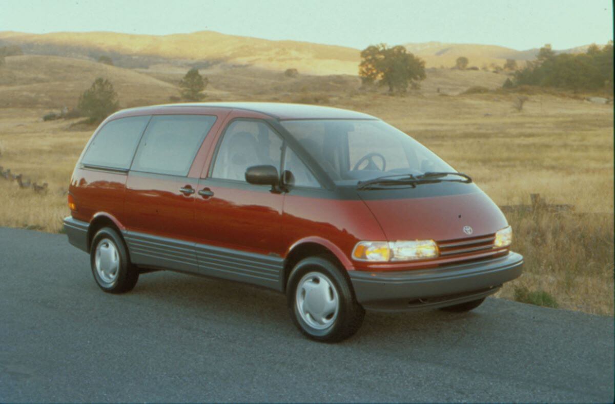 A 1991 Toyota Previa minivan model parked near dry and barren grass fields