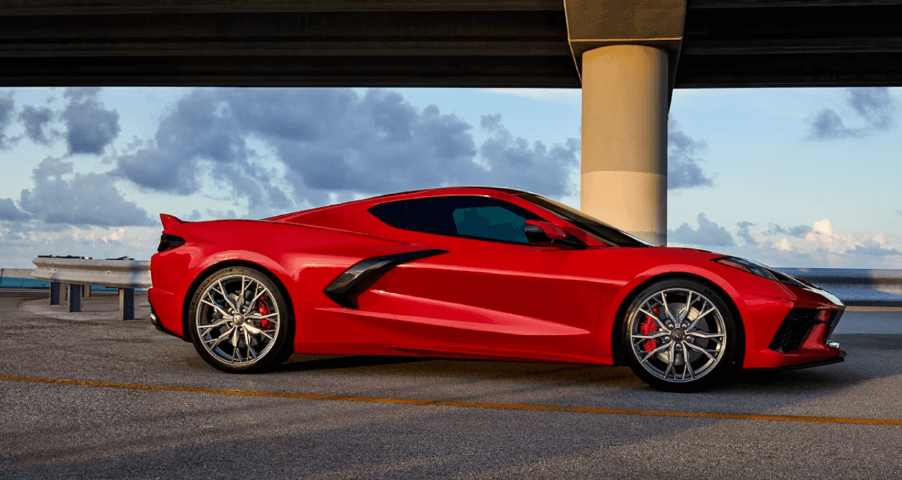 A 2024 Chevy Corvette Stingray performance sports car coupe model in Torch Red parked under a highway bridge
