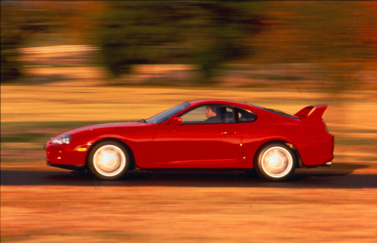 A side view of a red 1998 Toyota Supra