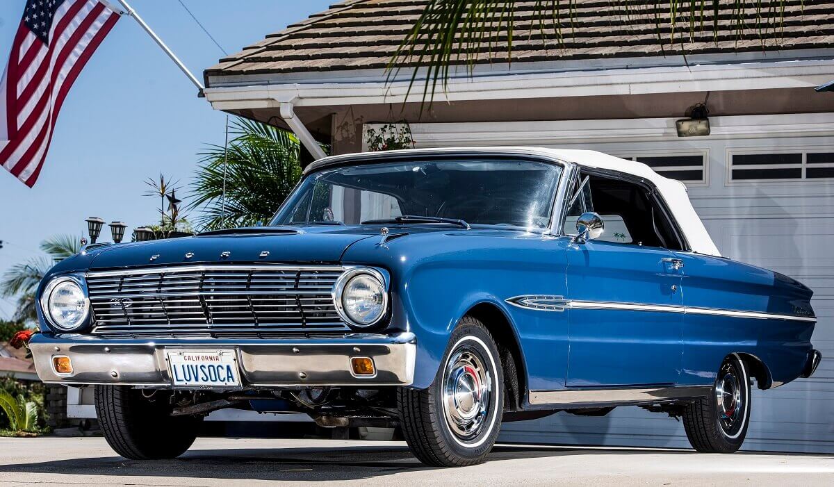 A blue and white 1963 Ford Falcon Futura Convertible shows off its fascia and soft top.