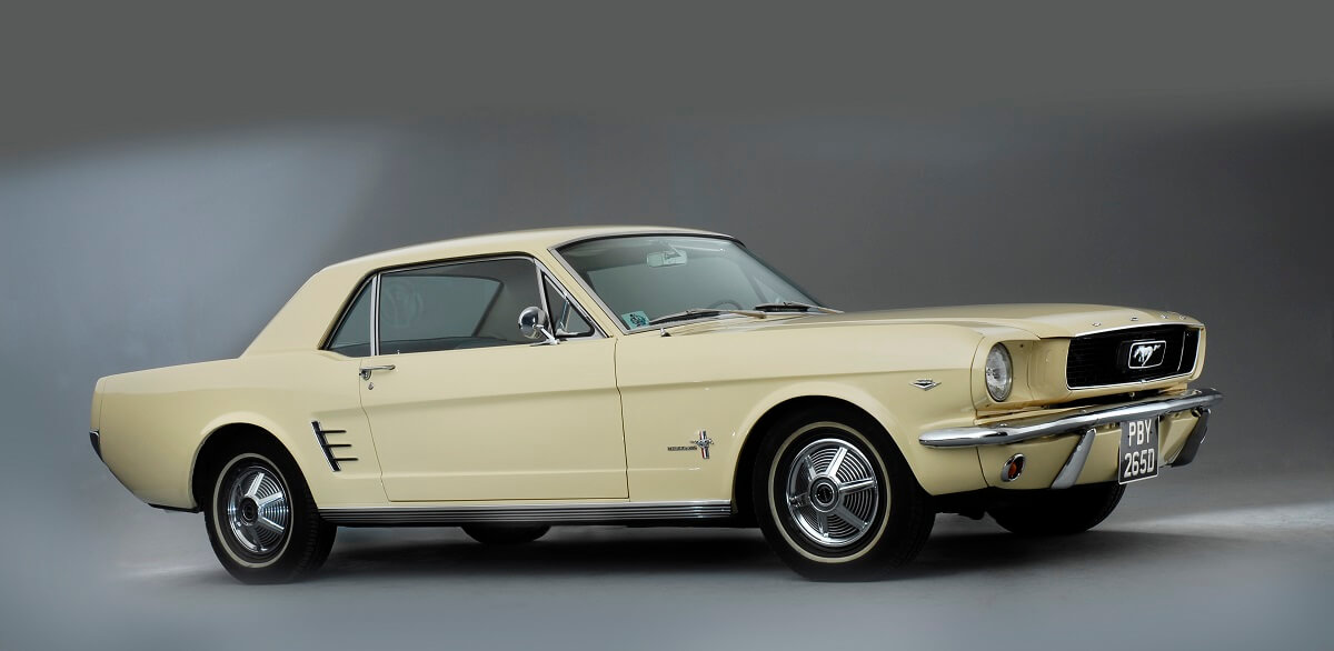 A cream-colored 1966 Mustang shows off its coupe styling.