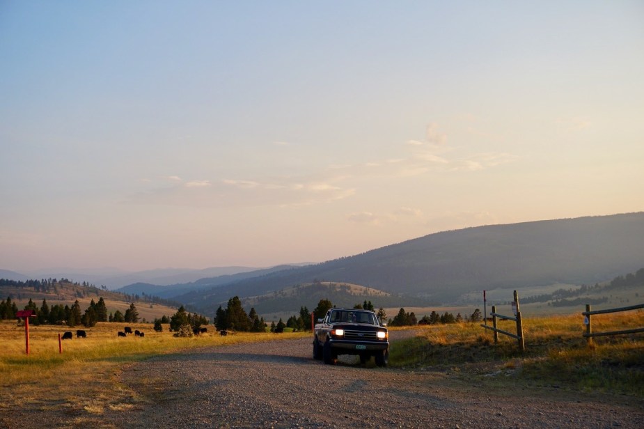 Old lifted ford Truck parked in a mountaintop pasture at sunset: similar old trucks and vintage SUVs make cheap off road vehicles.