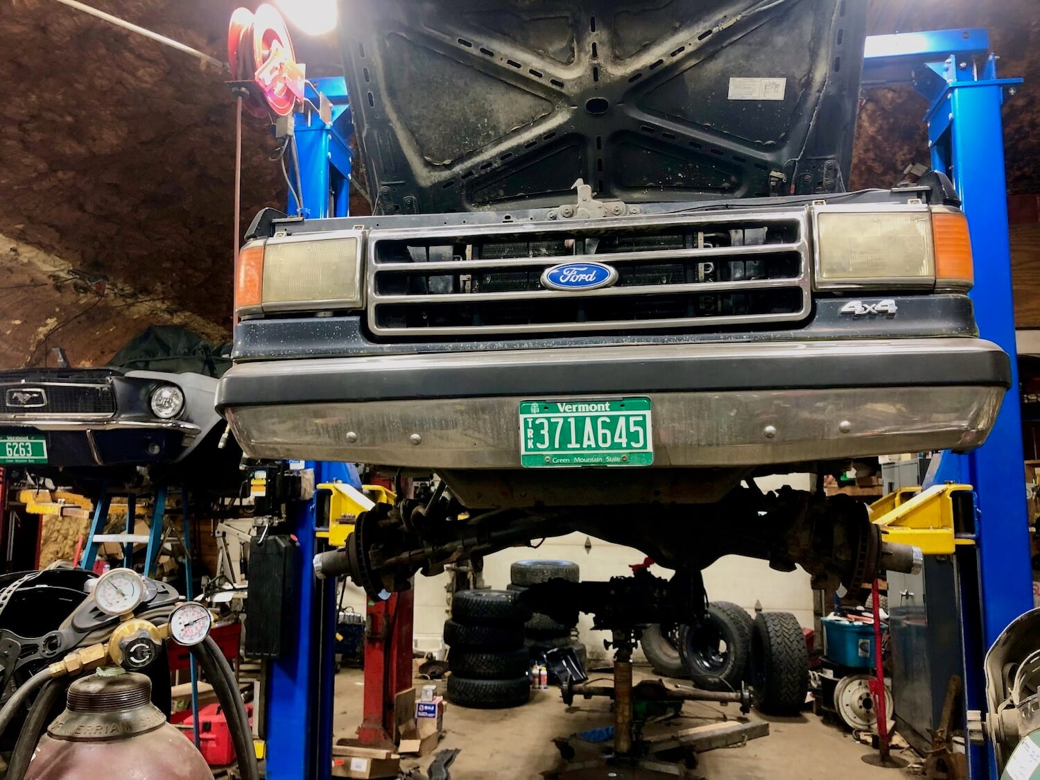 A 1988 Ford F-150 sitting on a lift in a garage.