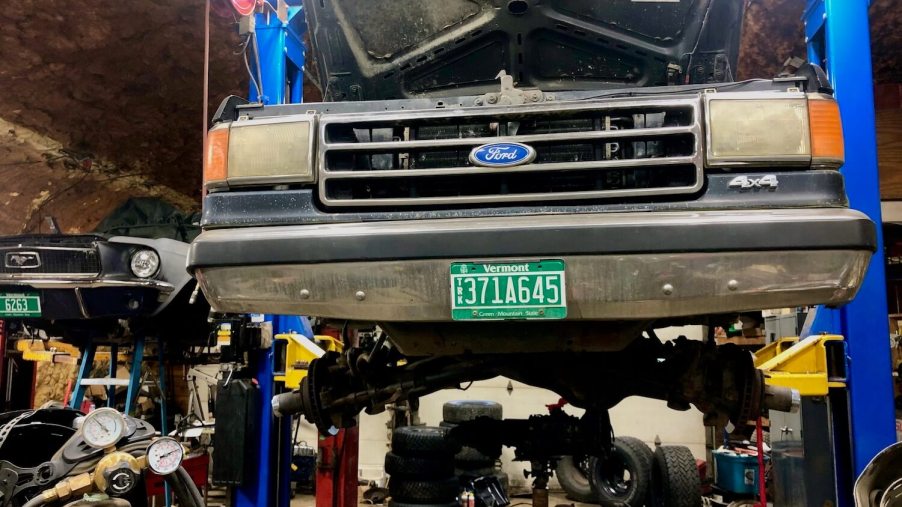 A 1988 Ford F-150 sitting on a lift in a garage.