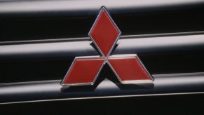 The Mitsubishi logo on an old Mighty Mountain Max 4WD compact pickup truck's grille.