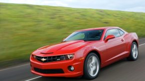A red 2010 Chevy Camaro SS blasts down a country road.
