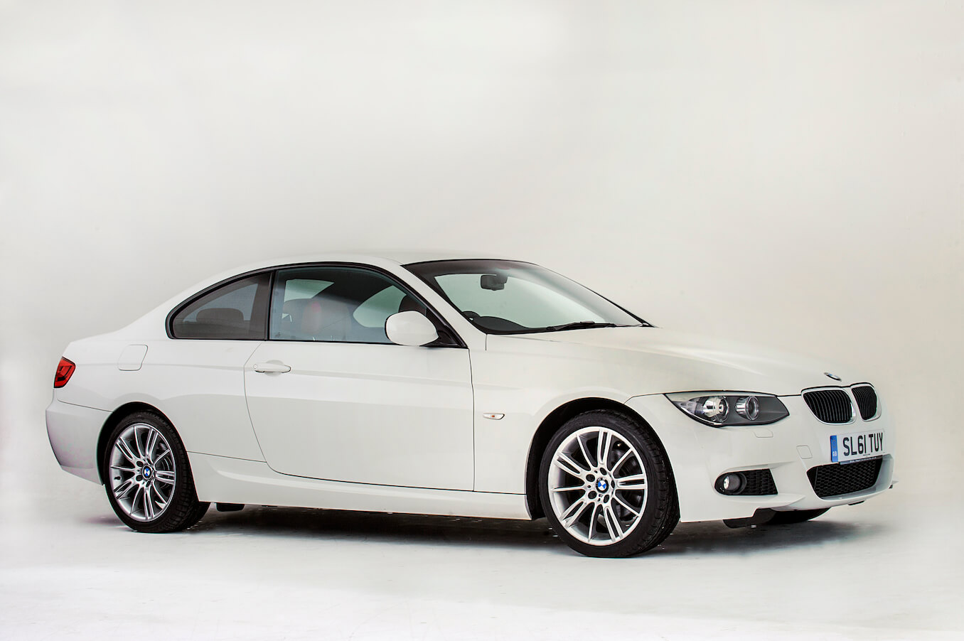 A 2011 BMW 3 Series in white on display against a white background. The 2011 BMW complaints get kind of weird.
