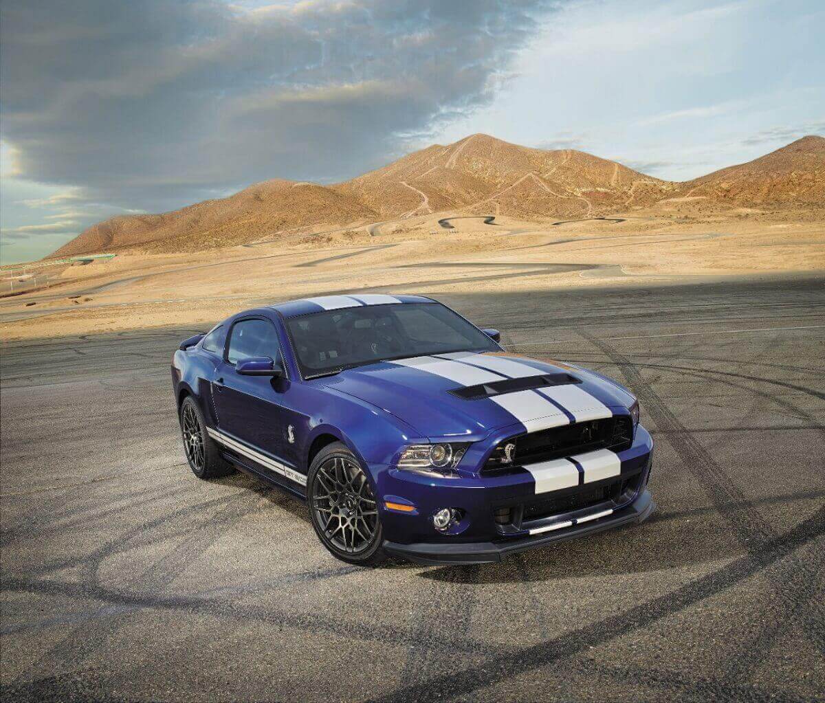 An S197 2013 Ford Mustang Shelby GT500 shows off its blue paintwork and white stripes.