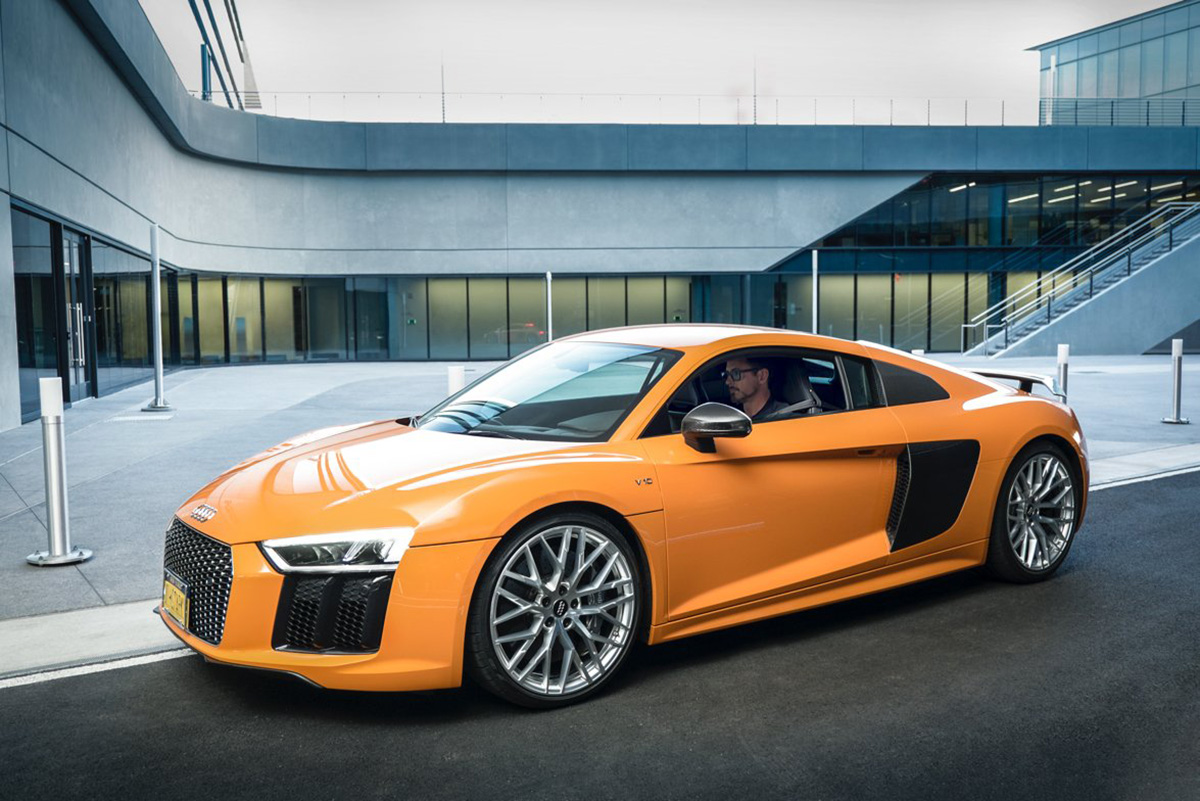 Side profile of a bright orange Audi R8 mid-engine supercar that was available until 2015 with a manual transmission