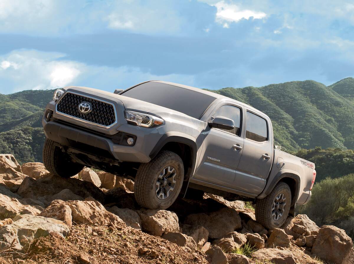 A dusty 2019 Toyota Tacoma TRD Off-Road midsize truck parked on rocks
