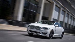 A white 2020 Lincoln MKZ drives down city streets.