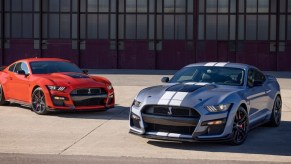 A pair of 2022 Ford Mustang Shelby GT500 coupes look like there's no faster car while sitting in front of a hangar.