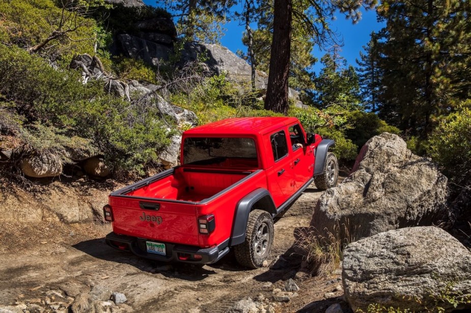 A red Jeep Gladiator Rubicon climbing on some rocks