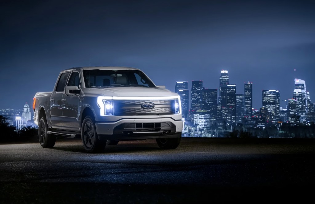The 2023 Ford F-150 Lightning parked in front of a city at night 