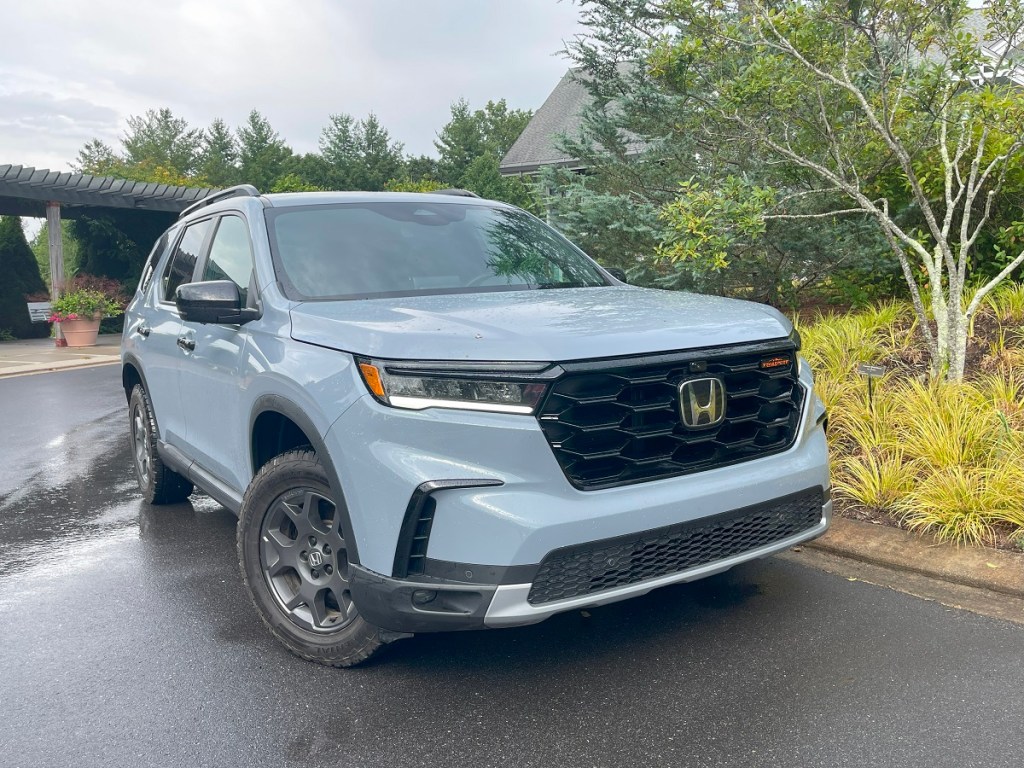 The 2023 Honda Pilot parked near foliage