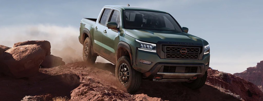 The 2023 Nissan Frontier off-roading over rocks