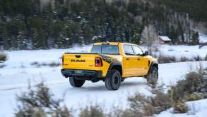 A special-edition Ram 1500 off-road truck in a unique yellow color driving through a snowy field.
