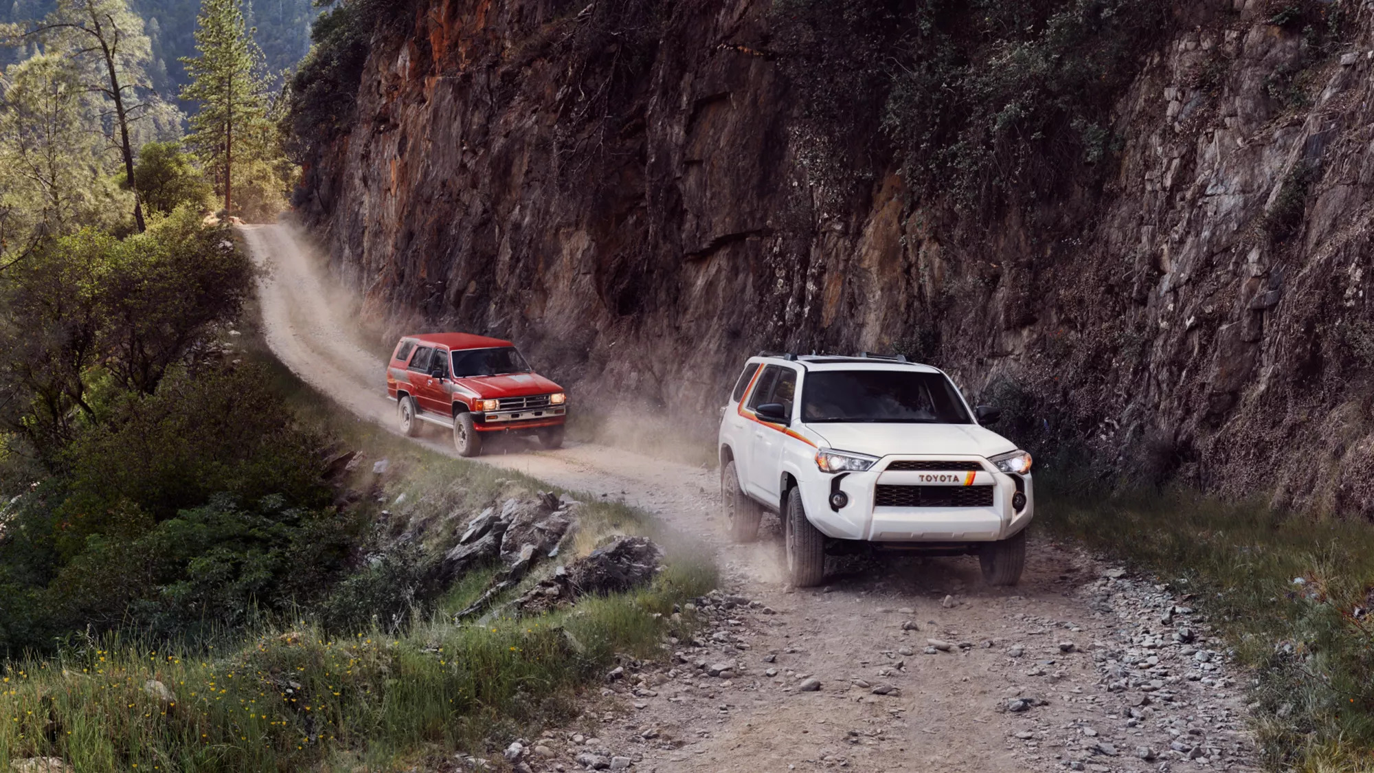 A white 2023 Toyota 4Runner is trailed by a previous iteration of the infamous SUV. 