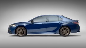 A blue 2023 Toyota Camry shows off its midsize car profile, a popular car for U.S. military personnel seeking vehicles.