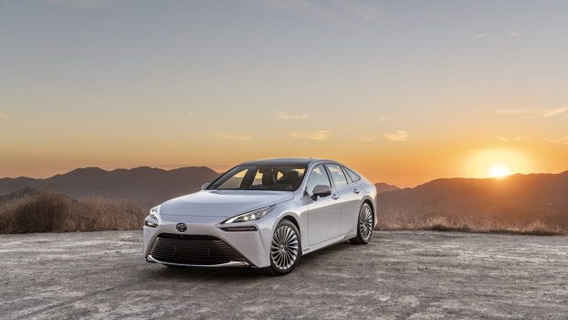 A white 2023 Toyota Mirai parked on a cliff at sunset. This Toyota SUV is off to a rough start in sales this year.