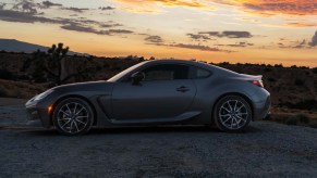 Side profile of a 2023 Toyota GR86 sports car sitting in a California desert sunset