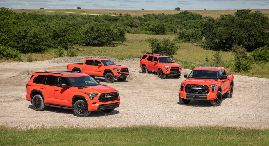 Four off-road Toyota TRD Pro trucks and SUVs parked with trees in the background.