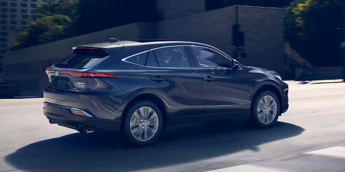 A gray 2023 Toyota Venza Limited hybrid SUV is driving on the road.