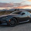 Front 3/4 of a 2023 Toyota GR86 sports car sitting in a California desert sunset