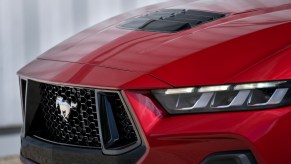 The front grille of the red 2024 Ford Mustang. Advantage goes to the Mustang in one area over the Chevy Camaro.