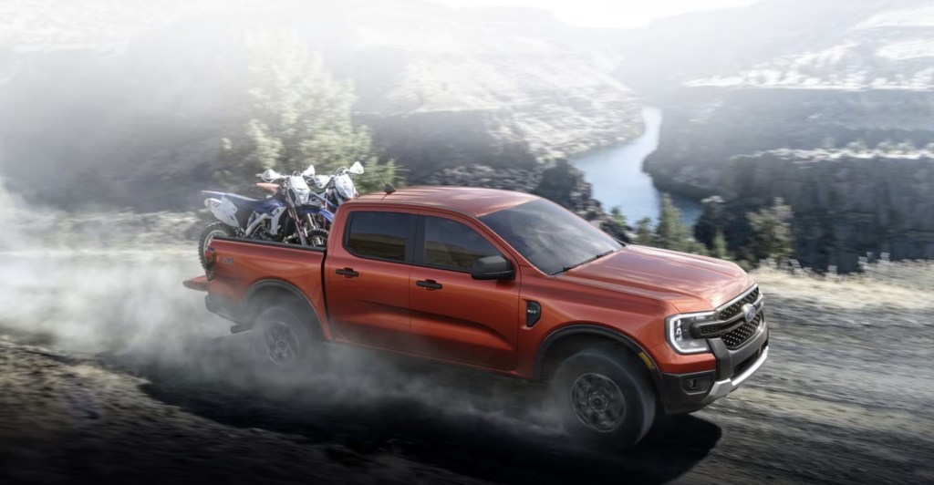 The 2024 Ford Ranger driving down the road with dirt bikes in the bed 
