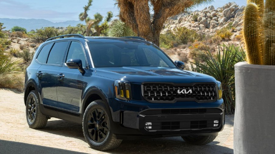 A blue 2024 Kia Telluride midsize SUV is parked outdoors.