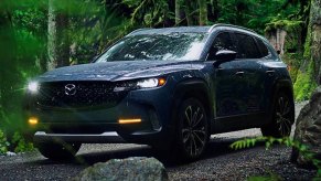 A blue 2024 Mazda CX-50 small SUV is parked off-road.
