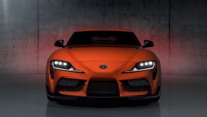 An orange 2024 Manual Toyota Supra 3.0 shows off its front-end styling.