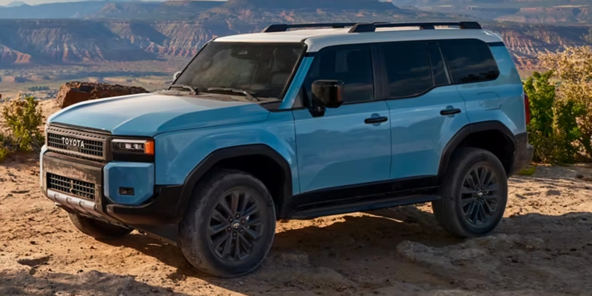 A blue 2024 Toyota Land Cruiser midsize SUV is parked outdoors.