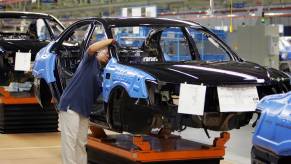A worker in a car assembly plant putting a car together.