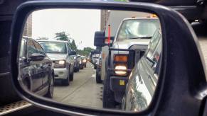 A view of traffic from a car's side view mirrors.