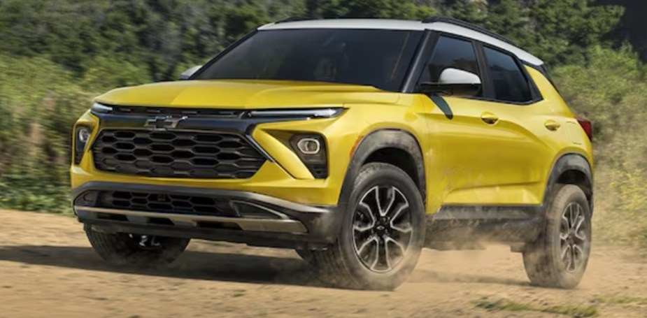A yellow 2023 Chevrolet Trailblazer subcompact SUV is driving off-road. 