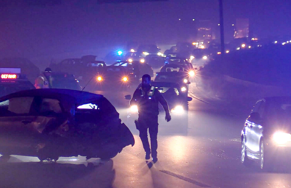 Lights shine in dense fog in a highway pileup