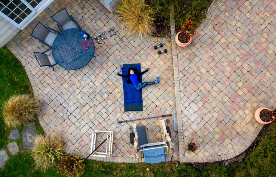 Drone shot of backyard with woman in chaise lounge