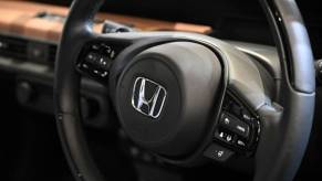 A closeup shot of a steering wheel in a Honda car.