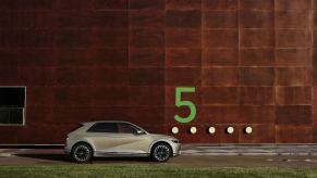 A silver 2023 Hyundai Ioniq 5 against a brick wall with a green 5. The Hyundai Ioniq 5's sales have ticked up