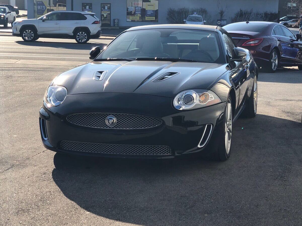 A black Jaguar XKR from the X150 generation shows off its convertible construction. 