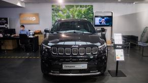 Black Jeep Compass 4xe on display in a showroom. Jeep Compass owners have a lot to say about their SUV.