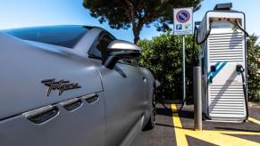 The all-electric Maserati GranTurismo Folgore grand tourer coupe model plugged into a charging station