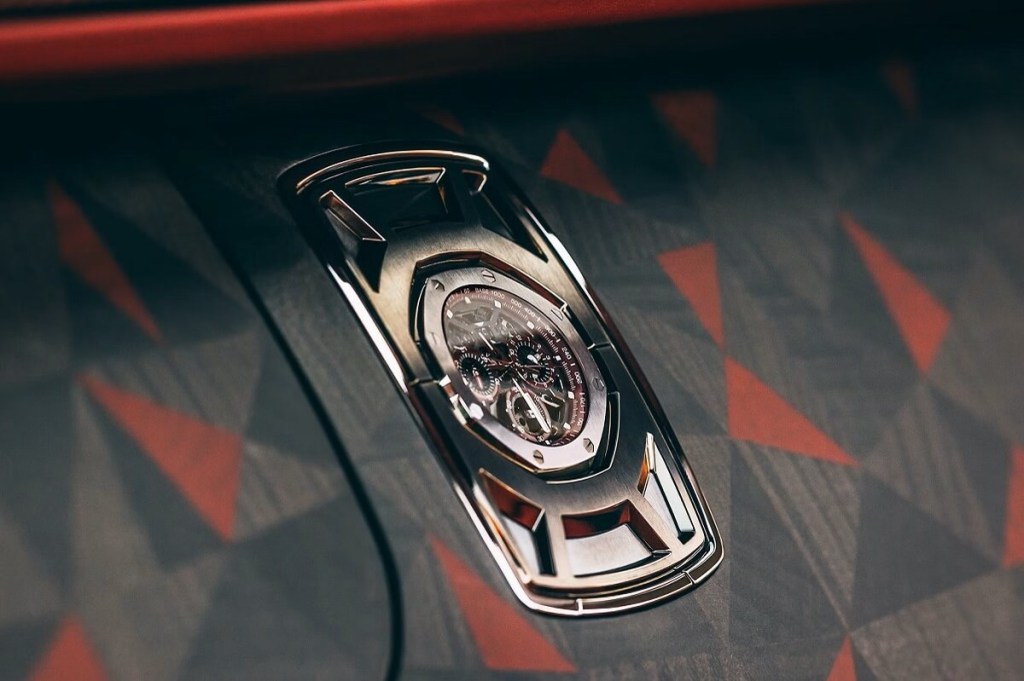 A Audemars Piguet Royal Oak Concept Split-Seconds Chronograph GMT sits in its dash station aboard a Rolls-Royce La Rose Noire Droptail luxury car.