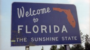 A highway sign welcoming car and semi-truck drivers to Florida.