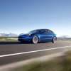 A blue 2022 Tesla Model 3 Long Range stretches its legs on a long country road.
