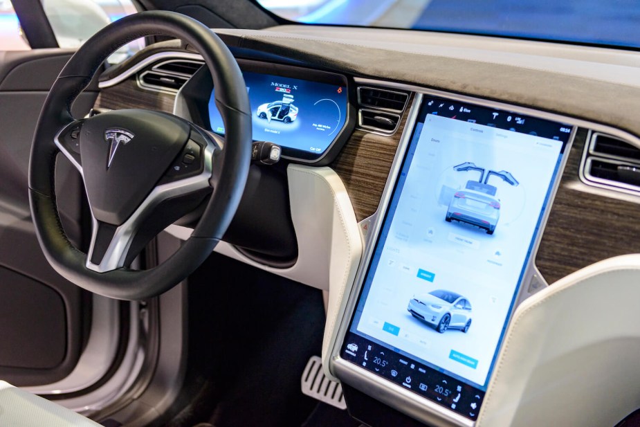 The large infotainment screen in a new Tesla, parked in a showroom.