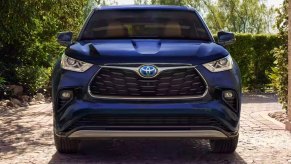 A blue 2023 Toyota Highlander Hybrid midsize hybrid SUV is parked.