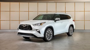 A white 2023 Toyota Highlander on display. The Highlander vs. Explorer debate can help you determine which model to buy next.